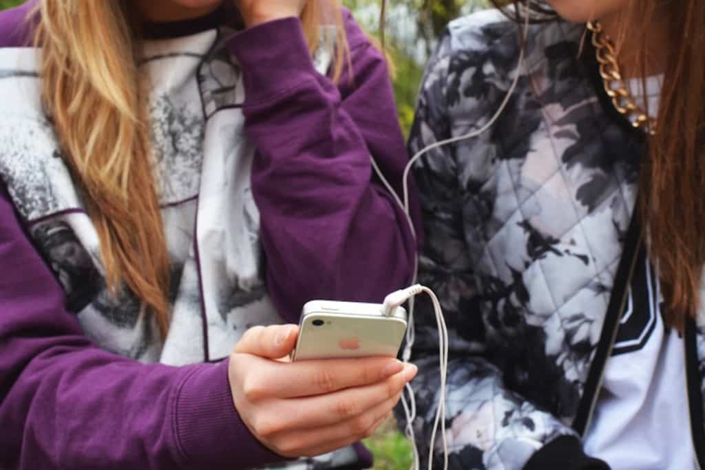 BFFs sharing headphones