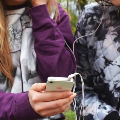 BFFs sharing headphones