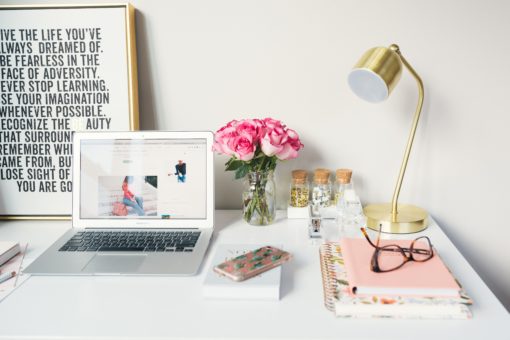 Desk with computer, flowers, lamp, and other accoutrements