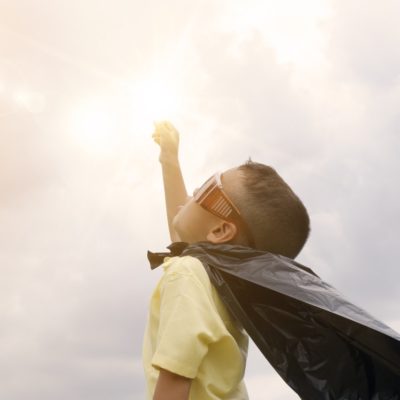kid superhero wearing a cape